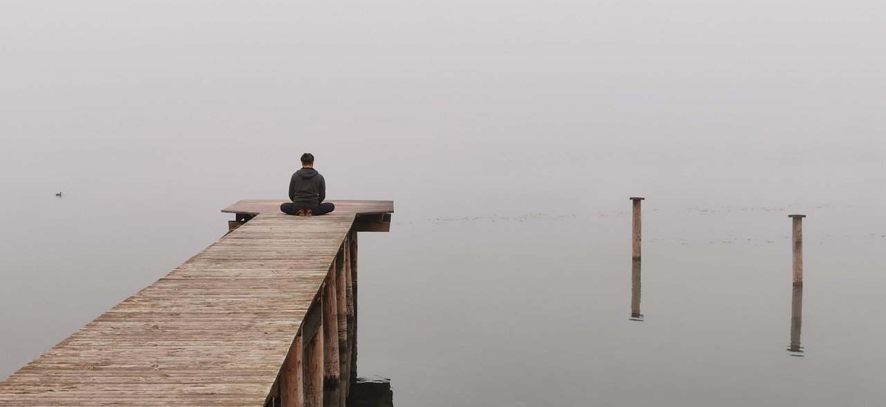 Homme meditant au bout d'un ponton